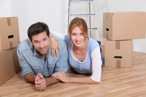 Mover carrying boxed household items carefully through a doorway
