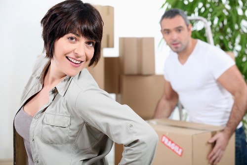 Professional movers carrying furniture in a Hampstead residential street